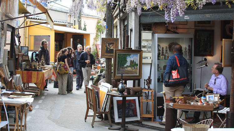 a still image of tourists in the alleyway of French marketplace looking at the artefacts in the shop